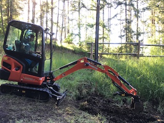 Petersen Plumbing's excavator on a hillside job.