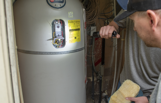 Examining a water heater. Petersen Plumbing examining a customer's water heater.