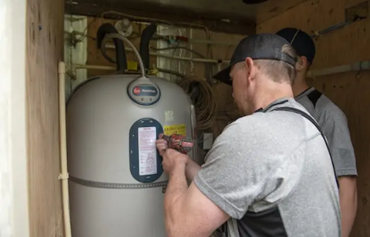 Petersen Plumbing employees work on a water heater.