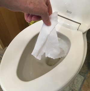 A hand flushing an antibacterial wipe.